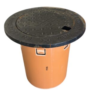 Körbart lock med teleskoprör, tät D400 är ett stort, runt svart brunnslock med strukturerad yta, rektangulär öppning och präglad kantskrift. Det vilar på en brun cylindrisk bas utrustad med sidohandtag.