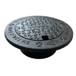 Ett runt, svart manhålslucka av gjutjärn med ett strukturerat triangelmönster och upphöjd text som visar EN 124 D 400, C-1500, och Körbar betäckning 315 tät, D400.