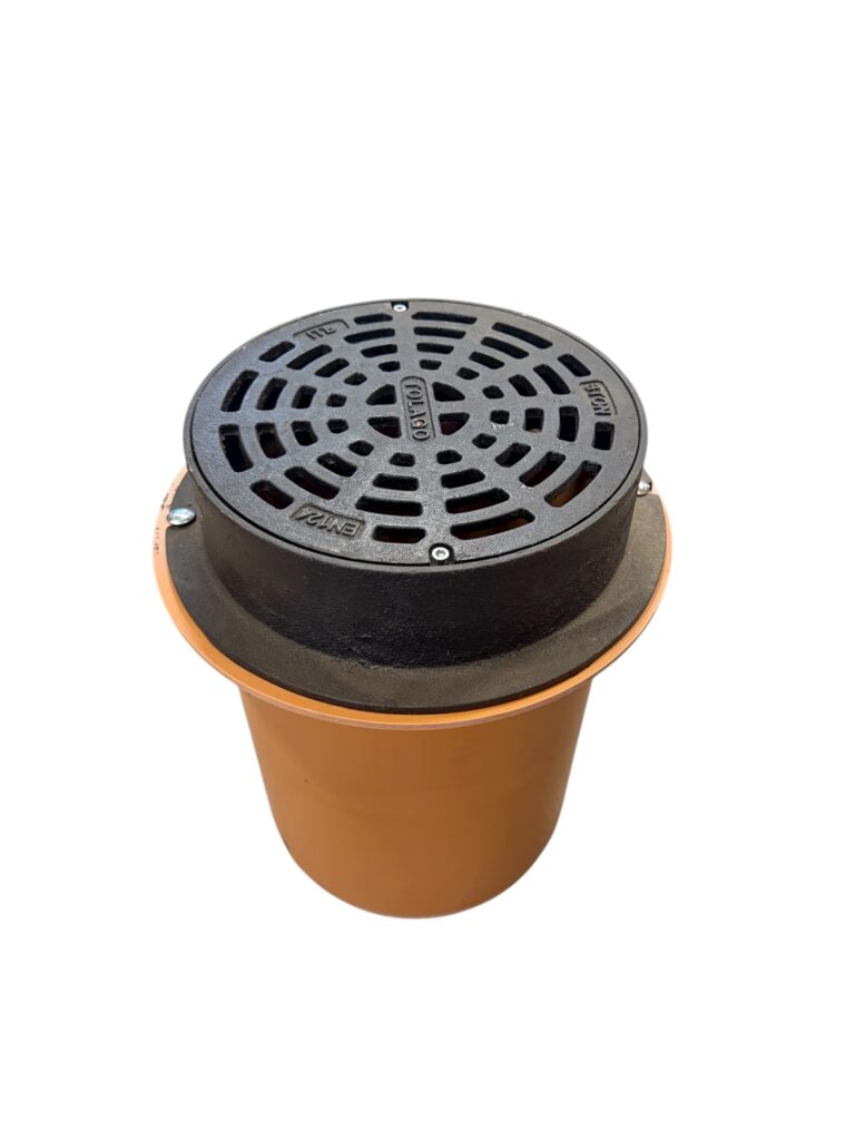 Lättbetäckning SIL med teleskoprör är en industriell golvbrunn med ett runt svart metallgaller och en orange cylinderformad bas, isolerad på en vit bakgrund.