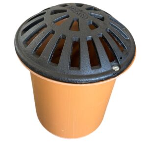 En rund avloppshink i orange plast med ett svart slitsat metallgaller på toppen, avsedd för vattenavrinning, mot en vit bakgrund.