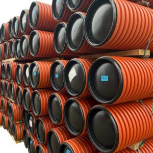 Dagvattenbrunn 400 - 2 meter: Flera orangefärgade, räfflade plaströr med svarta tätade ändar är horisontellt placerade på träpallar, vissa med etiketter och streckkoder, allt mot en vit bakgrund.