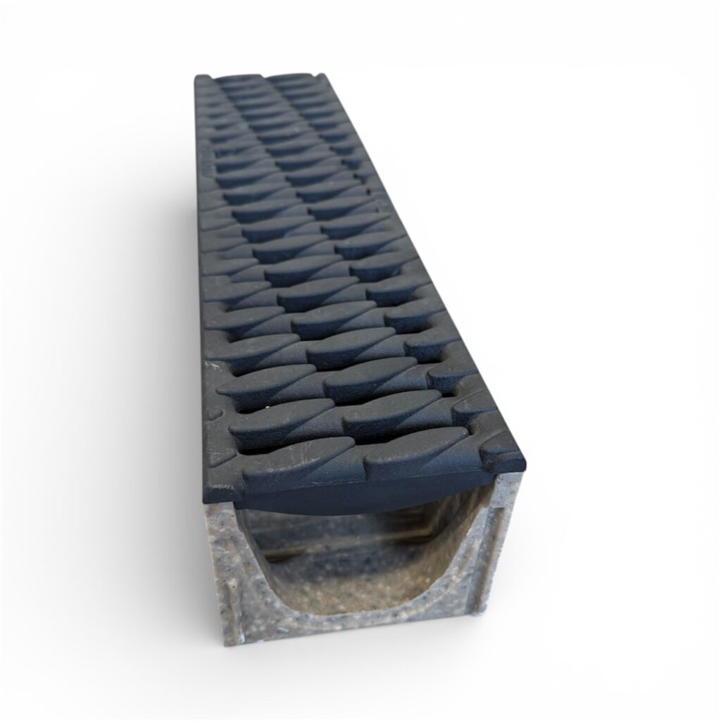 En närbild av ett trappsteg i metall med en svart, strukturerad, halkfri gummiyta, mot en vit bakgrund - med en hållbarhet jämförbar med SELF-100 SMART ränna med kompositgaller B125.