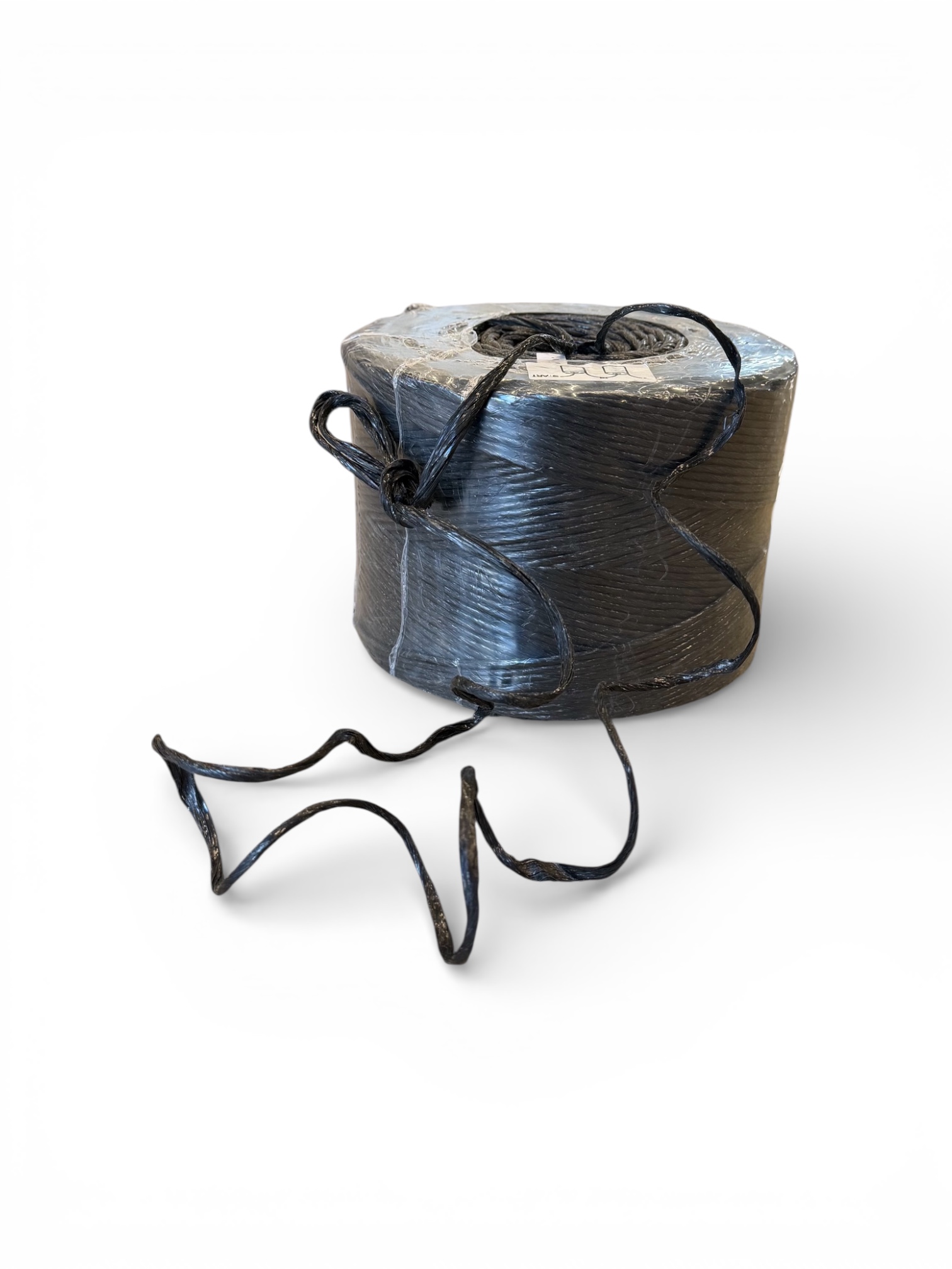 En delvis lindad rulle Dragtråd / Dragsnöre 3mm 750m (2,5 kg rulle) med lite ospolad svart lina visas mot en vit bakgrund.