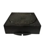 Lättbetäckning 300 sil fyrkantig (kopia) är ett svart, fyrkantigt gjutjärnslock med ett sirligt blommönster, två synliga skruvar och en strukturerad yta - lämpligt som dekorativt avlopps- eller servislock.