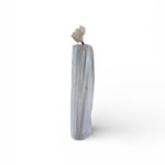 Ett högt, cylindriskt Markduk N2 2,4 x 25 meter, svart föremål inslaget i en vit plastpåse med ett rött snoddband knutet upptill står upprätt mot en vit bakgrund.