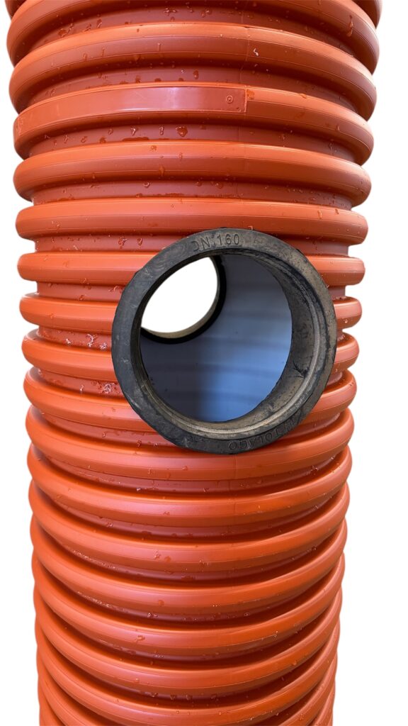 Närbild av ett orange korrugerat rör med en cirkulär öppning, som avslöjar den släta innerbeklädnaden och en annan öppning som syns genom rörets inre.