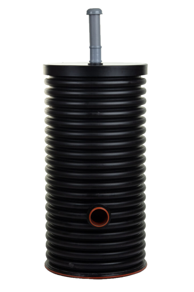 Ett Matala Biofilter 25 Hög gråvattenfilter, bestående av en stor svart, räfflad plastcylinder med ett plant lock, ett vertikalt grått rör på toppen och en cirkulär öppning med orange kant på sidan.
