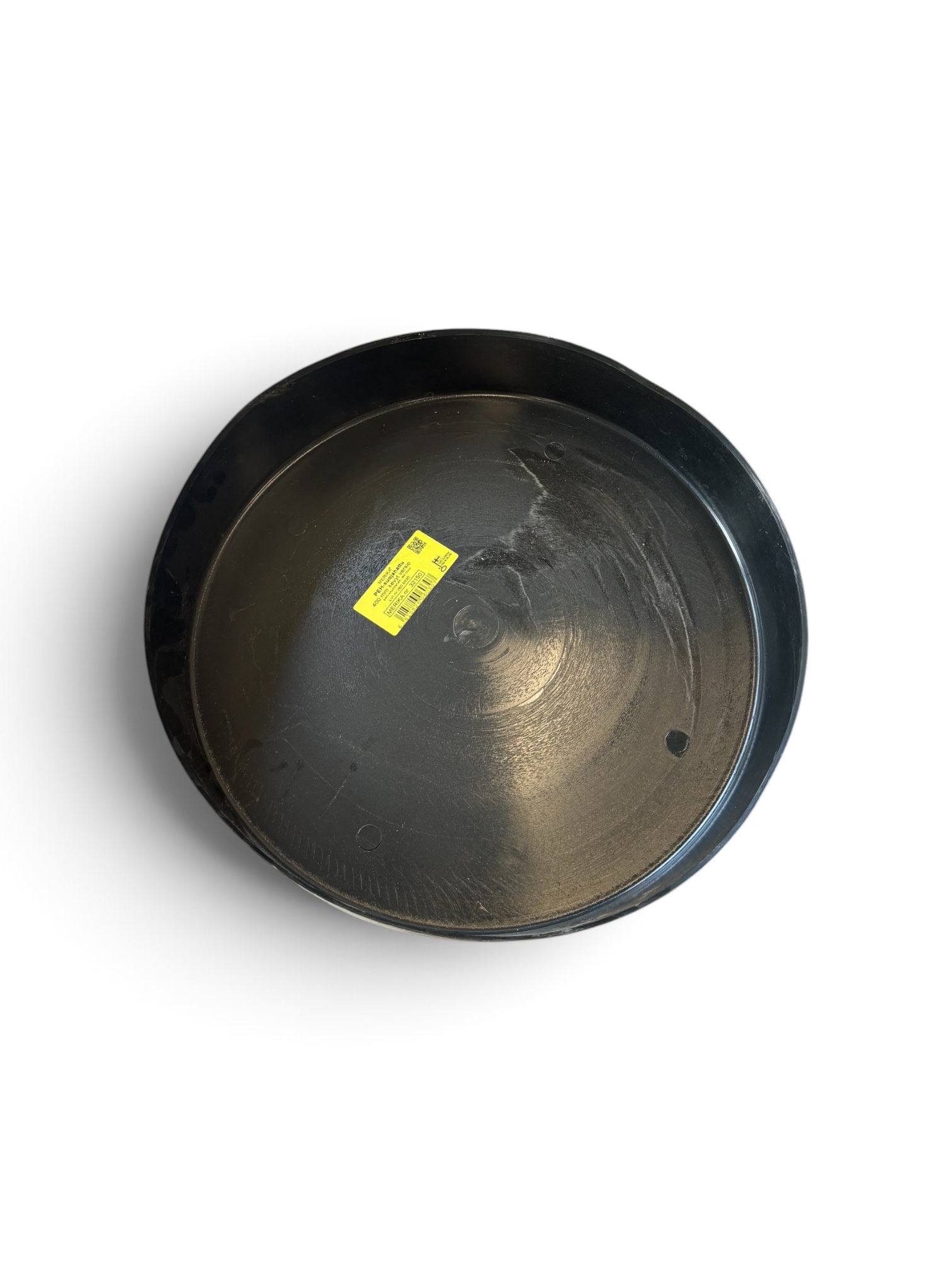 En svart, rund plastbricka, betecknad som ”Plastlock 400 mm till PP-stigarrör”, med en gul streckkodsetikett i mitten, placerad på en vit bakgrund.