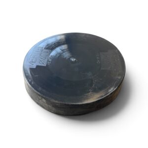 En svart, rund puck av massivt gummi med präglad text på ytan – märkt ”Plastlock 400 mm till PP-stigarrör” – är placerad på en vit bakgrund med en svag skugga under.