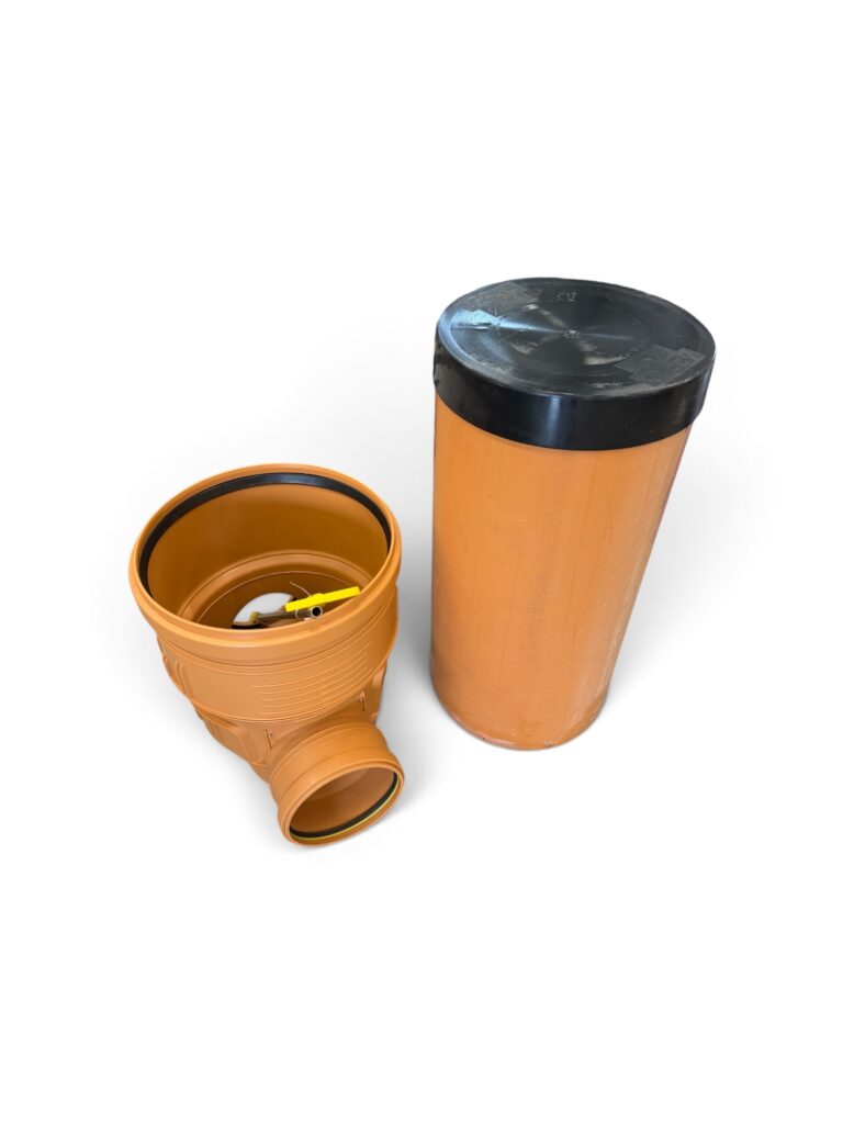 En orange plaströrskoppling med en svart tätning är placerad bredvid ett matchande orange cylindriskt lock, båda mot en vit bakgrund. Dessa komponenter ingår i systemet ”Tillsynsbrunn 400 mm med backventil – komplett system”, vilket garanterar tillförlitlig och långvarig prestanda för effektiv vattenhantering.